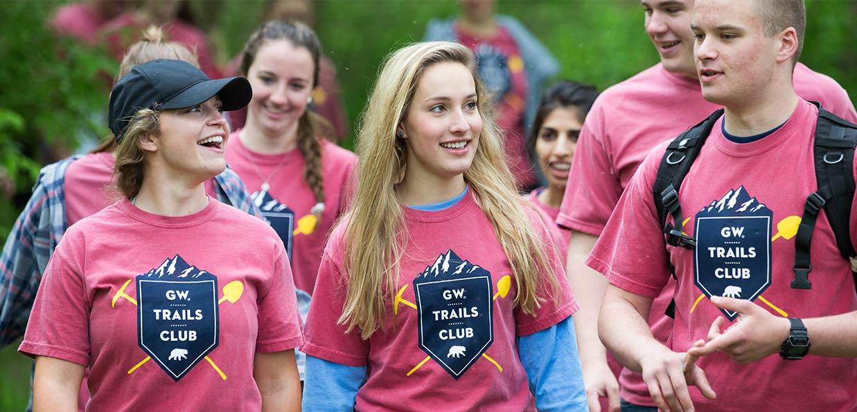 College students go on a hike together for trail club in custom t-shirts. 